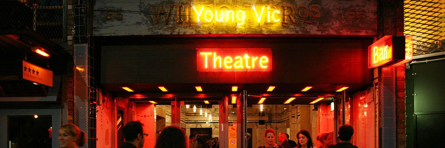 Entrance of theatre, Young Vic in yellow neon lettering and theatre in red neon lettering